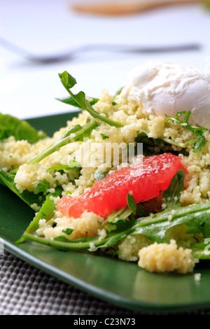 Couscous de rouge orange et rocket, oeuf poché sur le dessus Banque D'Images