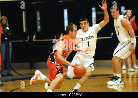 Une école guard tente d'arrêter l'avancée de l'opposition point guard. USA. Banque D'Images