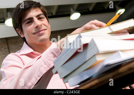 Étudiant, à, l'université, salle de classe, entre, livres, étudier, de préparer, un, examen, à la recherche, à, la, l'appareil photo. Banque D'Images