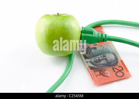 Bouchon électrique inséré dans la pomme verte avec la monnaie australienne ; fond blanc. Banque D'Images