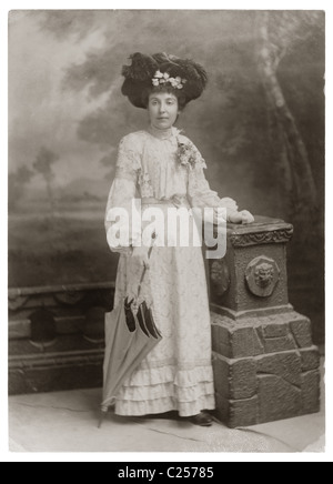 Portrait de studio de vogue, glamour jolie jeune femme portant un costume d'été, feather hat, tenant un parasol, dans la période édouardienne, début des années 1900, période , les femmes de style édouardien, vers 1903, au Royaume-Uni.