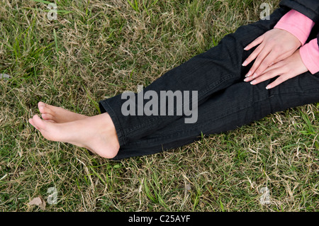 Close up of female university student jambes couché sur le campus Banque D'Images