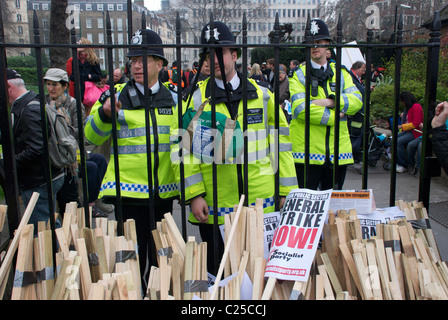 Les policiers regardent les frais de scolarité des étudiants les manifestants défilent sur le quai Victoria en direction de Westminster et de Trafalgar Square en 2010. Banque D'Images