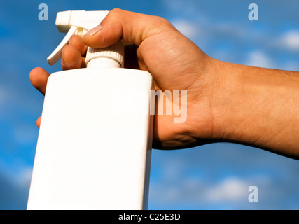 Homme Hand Holding White Vaporisateur contre fond de ciel bleu Banque D'Images