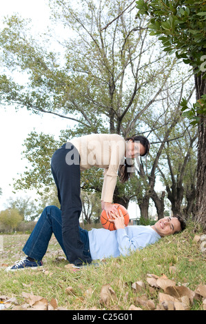 Campus, sport, couple, panier, de jeu, de la pratique, à l'université, campus,, parc, style de vie, sports, divertissements, des arbres, de l'après-midi. Banque D'Images