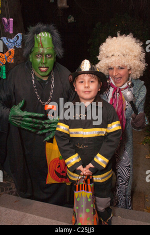 Maman et papa avec fireman fils l'observation et le traitement de l'Halloween. St Paul Minnesota MN USA Banque D'Images