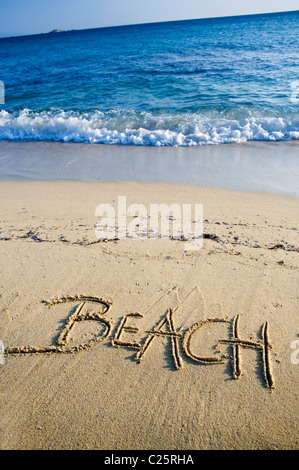 Plage de texte écrit sur le sable avec des vagues Banque D'Images