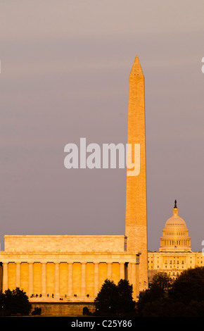 National Mall Lincoln Memorial Washington Monument US Capitol Building at Sunset Washington DC // WASHINGTON DC — vue des monuments célèbres le long du National Mall de Washington DC illuminé par les derniers rayons dorés du soleil couchant. De gauche à droite (et du premier plan à l'arrière-plan) se trouve le Lincoln Memorial, le Washington Monument et le Capitole des États-Unis. La photo est prise près du Mémorial Iwo Jima à Arlington, en Virginie, regardant vers l'est de l'autre côté du fleuve Potomac. La distance entre le Lincoln Memorial et le Capitole des États-Unis est de 2,3 miles - le long téléobjectif utilisé compresse la distance. Banque D'Images