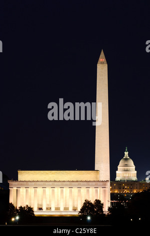 Lincoln Memorial Washington Monument le Capitole des États-Unis la nuit / WASHINGTON D.C. (États-Unis) — le Lincoln Memorial, le Washington Monument et le Capitole des États-Unis s'alignent le long de l'axe du National Mall dans cette vue de nuit téléphoto depuis Arlington, Virginie, de l'autre côté du fleuve Potomac. La distance réelle entre le Lincoln Memorial et le Capitole est de 2,3 miles (3,7 km), mais la longue distance focale se comprime en un seul cadre, faisant trois des structures civiques les plus emblématiques de l'Amérique semblent presque adjacentes. Banque D'Images