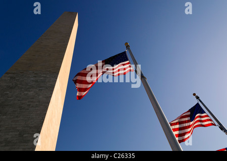 Washington Monument drapeaux américains Washington DC | WASHINGTON DC — les drapeaux américains flottent à la base du Washington Monument, leurs poteaux étant disposés en anneau qui entoure l’obélisque de marbre depuis 1959. Le puits de 555 pieds (169 m), conçu par Thomas Lincoln Casey, a pris trente-six ans pour être achevé en raison d'un arrêt du financement pendant la guerre de Sécession. Banque D'Images