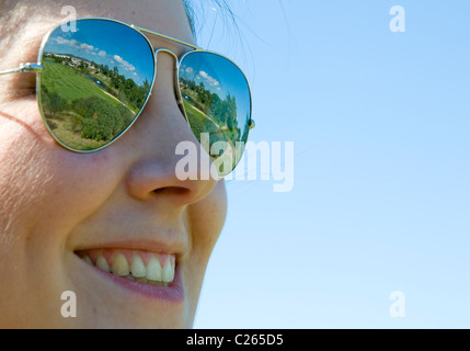 Une jeune femme portant des lunettes qui reflètent la disposition d'un terrain de golf de l'Algarve dans les lentilles Banque D'Images