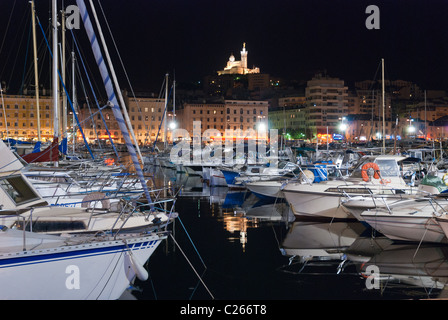 Le Vieux-Port de Marseille dans la nuit avec la chapelle Notre-Dame-de-la-Garde en arrière-plan. Banque D'Images