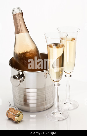 Bouteille de champagne dans le refroidisseur et deux verres de champagne. Isolé sur fond blanc. Banque D'Images
