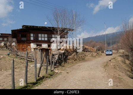 Route avec une voiture et des maisons de village, Ura, le Bhoutan central Banque D'Images