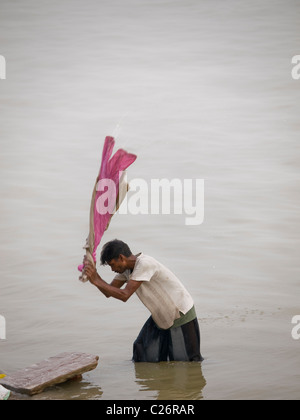 Homme faire la lessive à l'un des ghats de Varanasi, Inde Banque D'Images