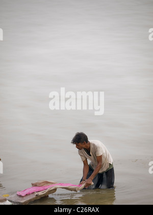 Homme faire la lessive à l'un des ghats de Varanasi, Inde Banque D'Images