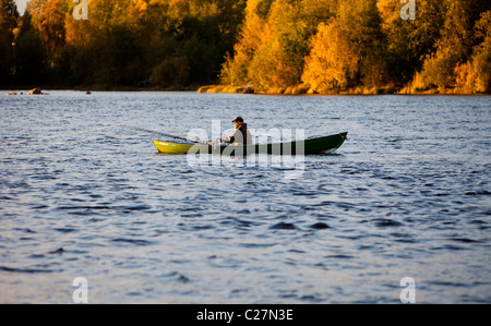 Pêche à la traîne d'un barque / skiff / canot à la rivière Oulujoki près du centre-ville à Oulu, Finlande Banque D'Images