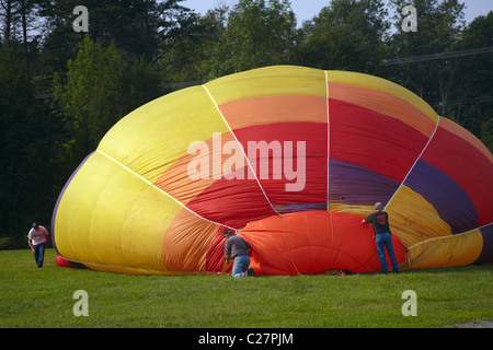 Trois hommes travaillent le gréement du gonflement ballon à air chaud. Banque D'Images