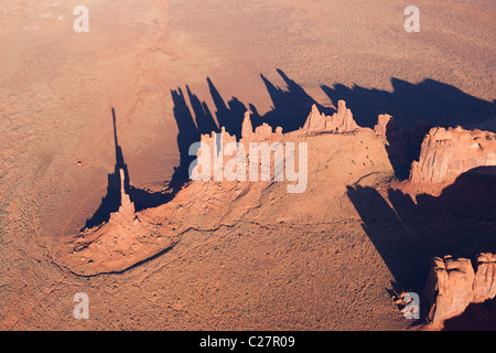 VUE AÉRIENNE.Pinnacles en grès rouge de Totem Pole (à gauche) et de Yei Bi Chei dans Monument Valley.Terre indienne Navajo, Arizona / Utah, États-Unis. Banque D'Images