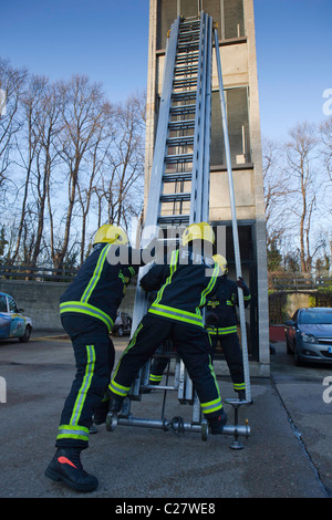 La gare de London Fire Brigade, session de formation sur le deuxième étage de la tour. Fire fighter configurer les échelles. Banque D'Images
