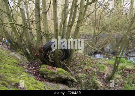 Un pneu de voiture et d'un dumping de roue à côté de la rivière Thames près de Richmond, Surrey Banque D'Images