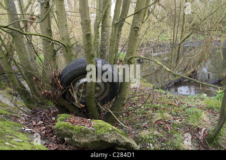 Un pneu de voiture et d'un dumping de roue à côté de la rivière Thames près de Richmond, Surrey Banque D'Images