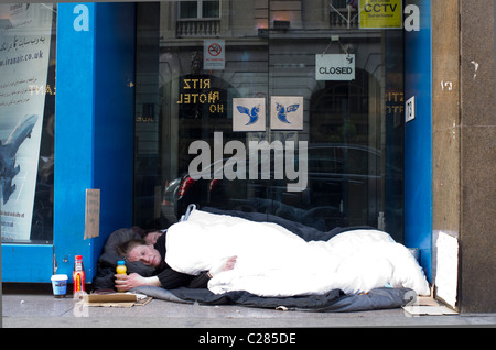 Un couple de sans-abri dormir dans la porte en face de l'Hôtel Ritz à Piccadilly, Londres, Angleterre Banque D'Images