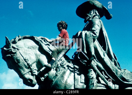 Jeune garçon joue sur statue de Conquistador équitation sur cheval dans un parc de San Francisco Banque D'Images