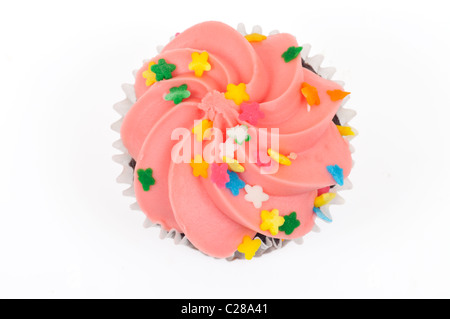 Cupcake au chocolat avec glaçage rose décoré de saupoudre de dessus sur fond blanc découpé. Banque D'Images