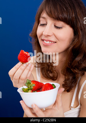 Belle et happy young woman eating strawberries Banque D'Images