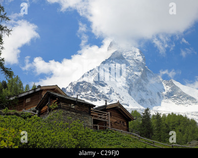 Peu de maisons en bois en face de l'énorme montagne Matterhorn près de Zermatt en Suisse Banque D'Images