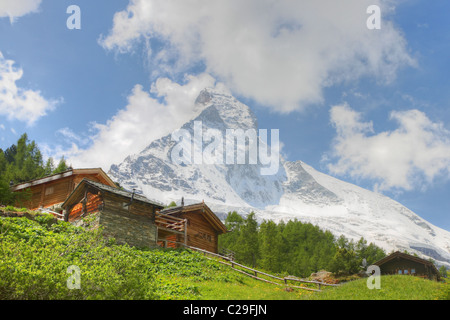 Village Suisse Règlement des maisons en bois en face de forêt de la puissante recouvert de neige Cervin en Valais, Suisse Banque D'Images