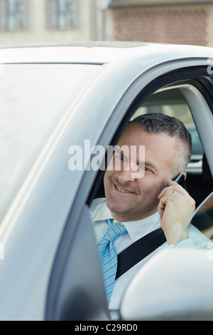 Young caucasian business man appelant sur le téléphone et sourit. La forme verticale, vue de côté, la tête et épaules Banque D'Images