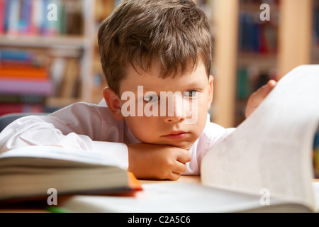Close-up of cute boy la préparation de la leçon dans la bibliothèque Banque D'Images