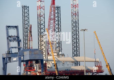 Les éoliennes d'être chargés sur un automoteur plate-forme avant de la voile au parc éolien offshore, Port International d'Harwich, Essex, Royaume-Uni. Banque D'Images