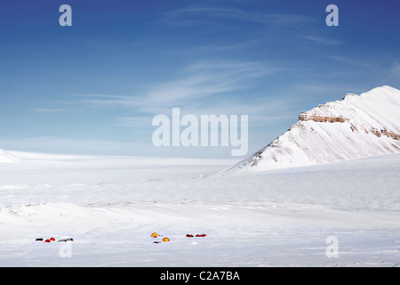 Une expédition d'hiver sur un paysage de montagne, des tentes dans la distance Banque D'Images