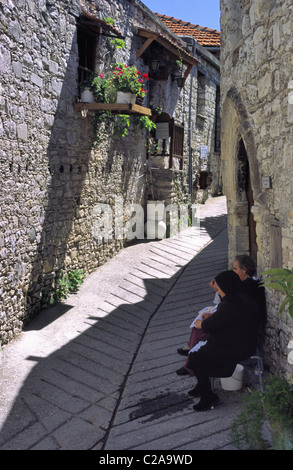 Mesdames faire lace dans une rue pittoresque à Omodos, Chypre. Banque D'Images