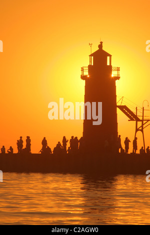 Les gens silhouette phare coucher du soleil à South Haven Michigan Banque D'Images