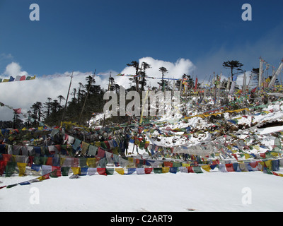 La neige et les drapeaux de prières à Thrumshingla, passer la frontière entre le centre et l'est du Bhoutan Banque D'Images