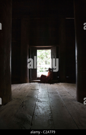 Bagaya Kyaung monastère, Amarapura, Myanmar, moine à la hors de la porte dans la pensée Banque D'Images