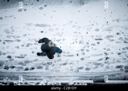 Man Walking on snow-covered street, high angle view Banque D'Images