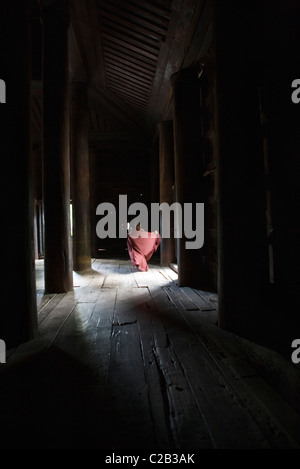 Bagaya Kyaung monastère, Amarapura, Myanmar, moine d'exécution dans la distance Banque D'Images