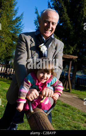 Grand-père et sa petite-fille sur une balançoire Banque D'Images