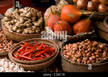 Paniers de fruits, de gac le piment, les oignons, les échalotes, le gingembre et l'ail dans un marché dans le vieux quartier de Hanoi, Viet Nam Banque D'Images