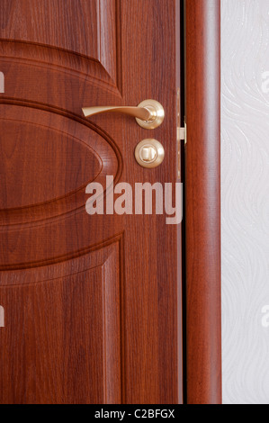 La poignée de porte. Une porte en bois, poignées en laiton. Banque D'Images