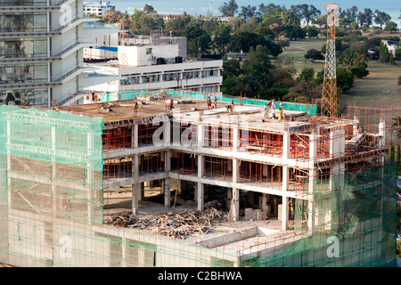 Bâtiment à plusieurs étages à ossature en béton en construction avec filet de sécurité vert, Dar es Salaam, Tanzanie Banque D'Images