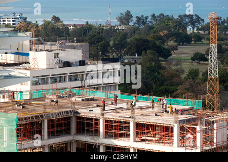 Ouvriers de la construction sur un chantier de construction à plusieurs étages avec vue sur le port, Dar es Salaam, Tanzanie Banque D'Images