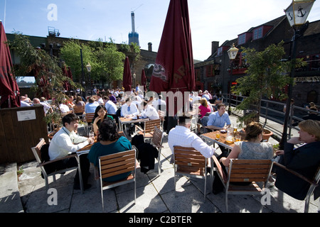 Les employés de bureau à l'extérieur manger près de the Pub sur la rive sud de la Tamise à Londres. Banque D'Images