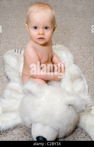 Baby sitting sur l'ours blanc tapis. St Paul Minnesota MN USA Banque D'Images