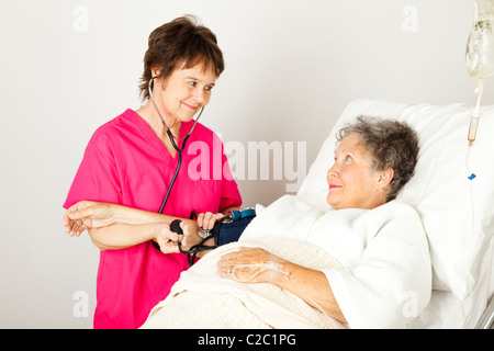 L'infirmière prend une haute pression artérielle du patient à l'hôpital. Banque D'Images